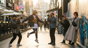 Young people taking photos in a trendy Seoul street fashion district